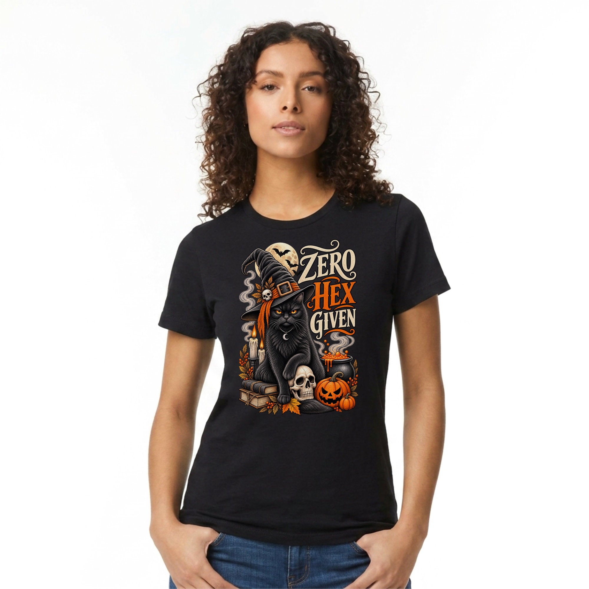 A woman wearing a black graphic t-shirt with a Halloween-themed design featuring a black cat, skulls, pumpkins, and the text 'ZERO HEX GIVEN'.