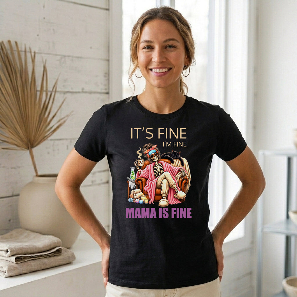 A woman wearing a black graphic t-shirt with a 'Mama is Fine' skeleton joke print, standing in a bright, modern room with white walls and a window.