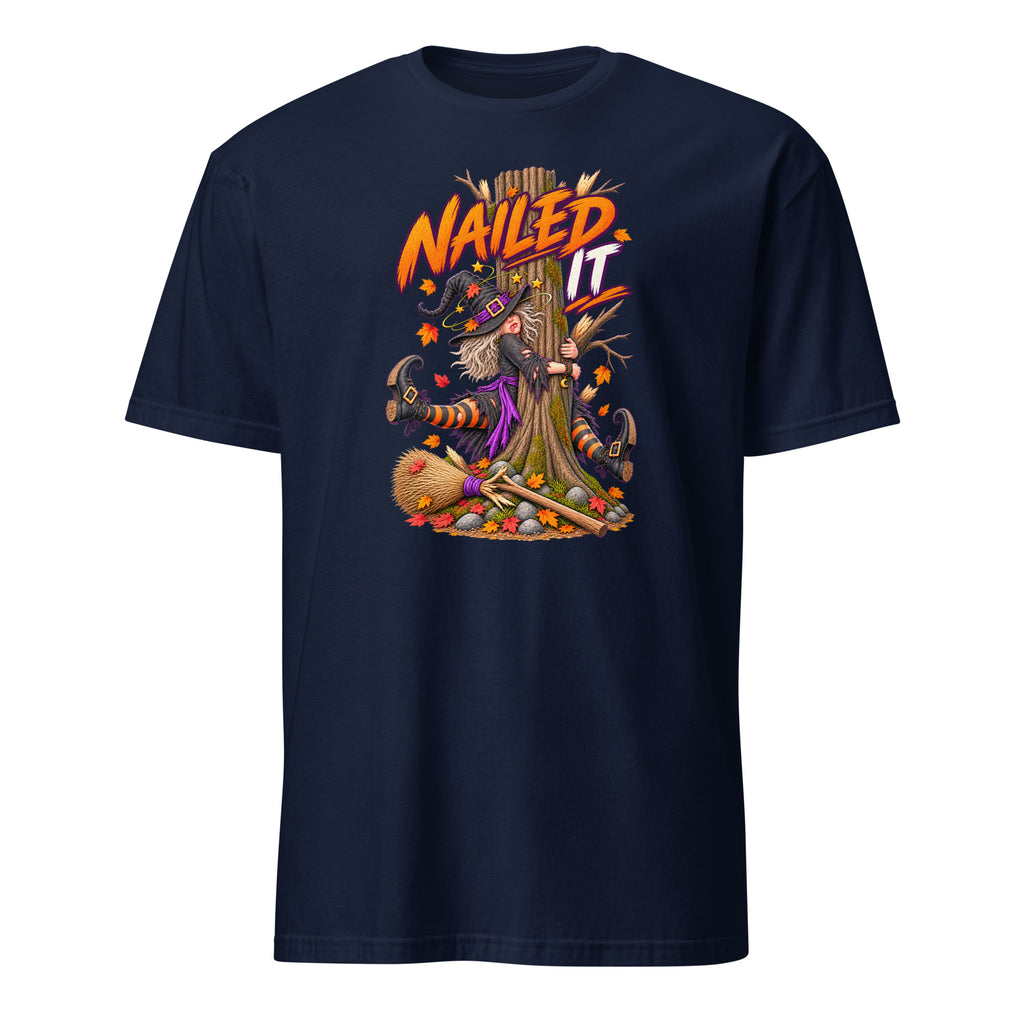 A navy blue short-sleeve crewneck t-shirt featuring a colorful graphic print on the front. The graphic shows a witch riding a broomstick with the text 'NAILD IT' in orange and yellow, surrounded by autumn and Halloween elements like a broom, pumpkin, and acorns.