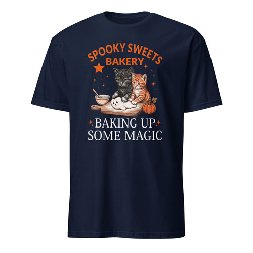 A navy blue short-sleeve t-shirt with a graphic print on the front. The graphic features the text 'SPOOKY SWEETS BAKERY' in orange and 'BAKING UP SOME MAGIC' in white, surrounding an illustration of two cats (one black, one orange) baking with sugar and a pumpkin on a wooden board.
