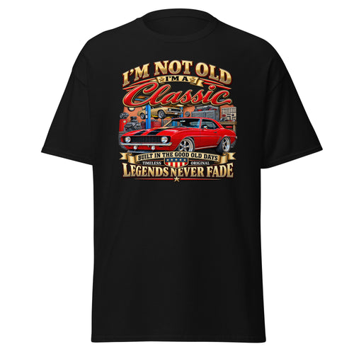 A black short-sleeve t-shirt with a large graphic print on the front. The graphic features a red classic muscle car and stylized text reading 'I'M NOT OLD I'M Classic' and 'LEGENDS NEVER FADE'.