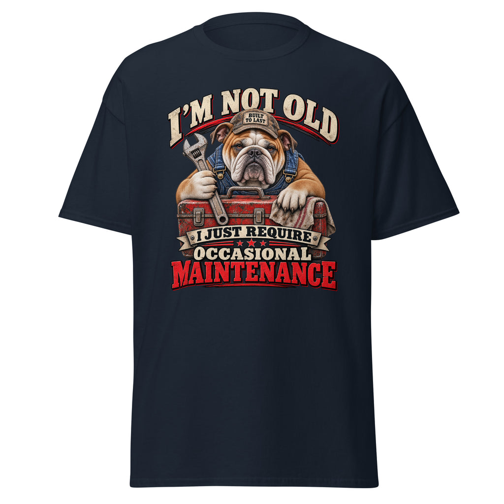 A navy blue short-sleeve t-shirt with a large graphic print on the front. The graphic features an illustration of a bulldog wearing a mechanic's hat and holding a wrench over a red toolbox, surrounded by the text 'I'M NOT OLD I JUST REQUIRE OCCASIONAL MAINTENANCE' in stylized lettering.
