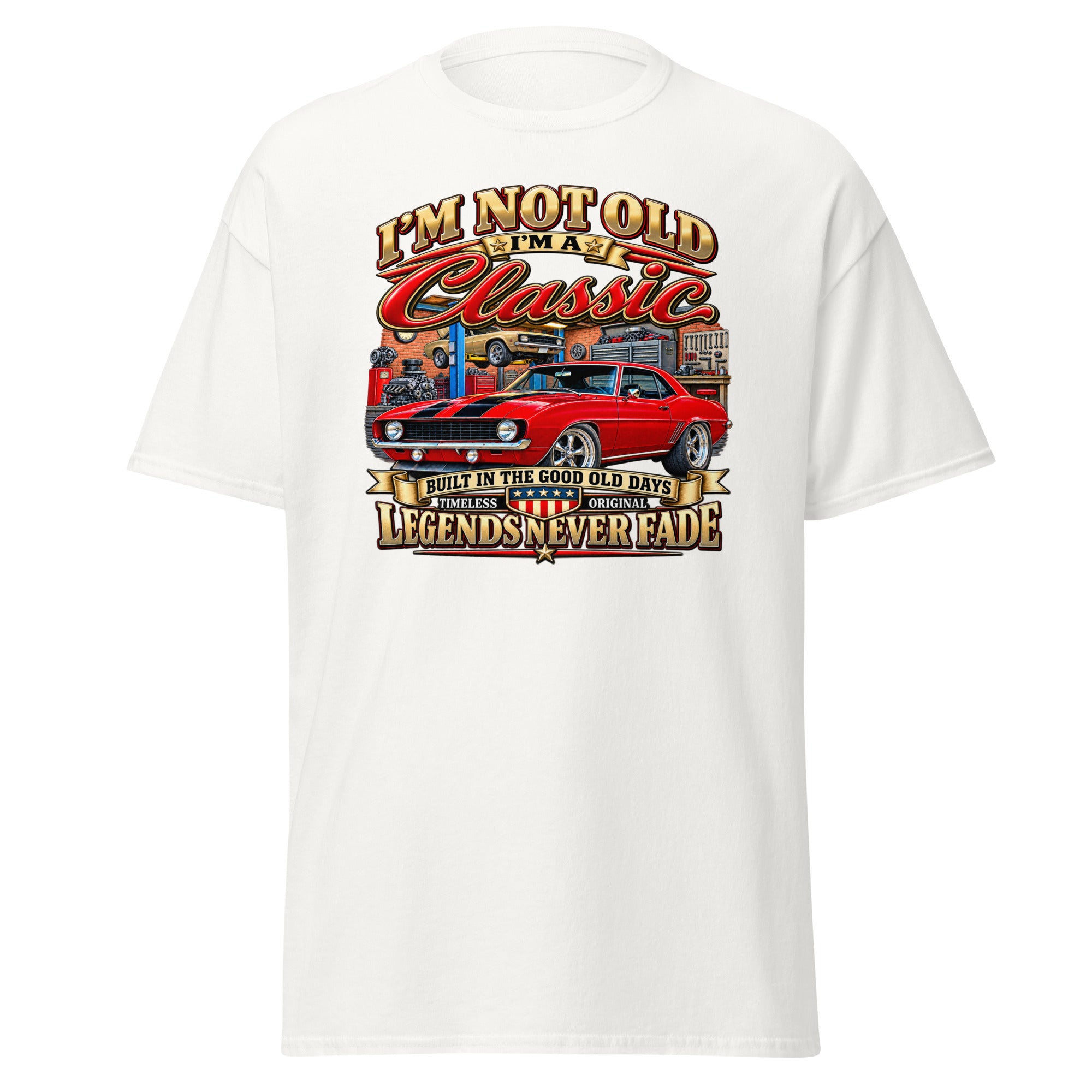 A white short-sleeve crewneck t-shirt featuring a large graphic print on the front. The graphic displays a red classic muscle car with a garage background and stylized text reading 'I'M NOT OLD I'M Classic' and 'LEGENDS NEVERFADE'.