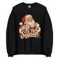 A black crewneck sweatshirt featuring a vintage-style graphic of Santa Claus holding a mug and cookie with the text 'Tis The Season' in red and cream lettering.