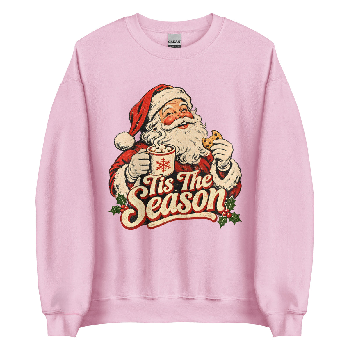 A light pink crewneck sweatshirt featuring a vintage-style graphic of Santa Claus holding a mug with the text 'Tis The Season' in red and cream lettering.