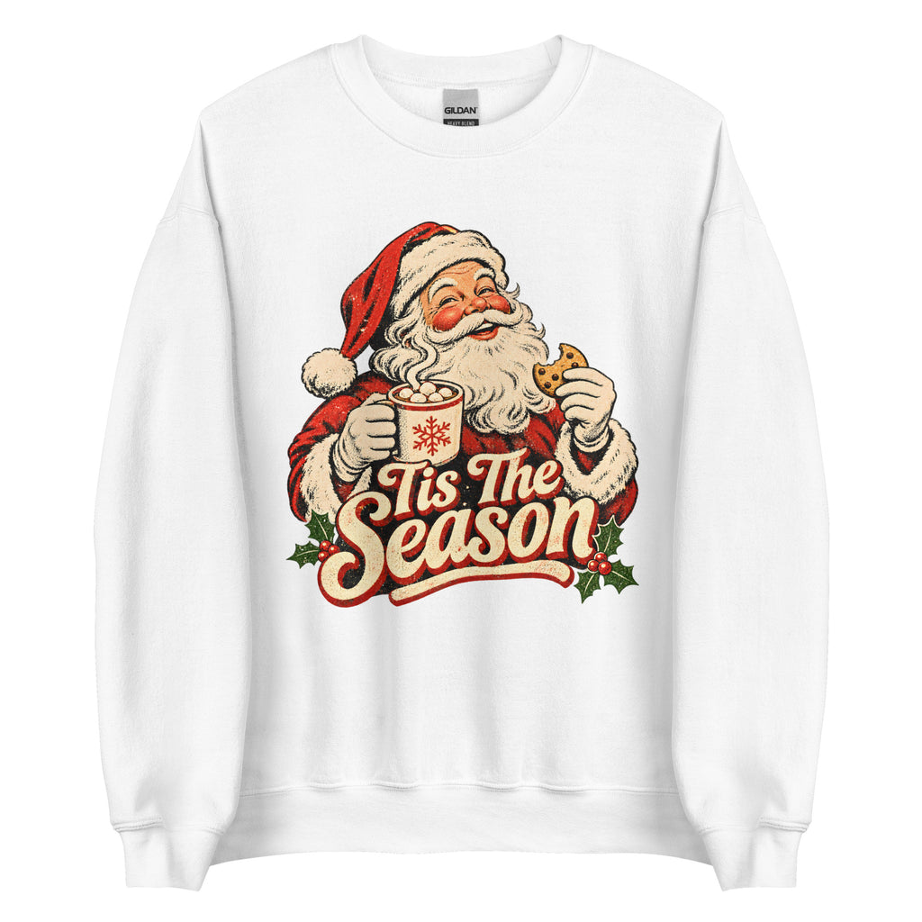 A white crewneck sweatshirt featuring a vintage-style graphic of Santa Claus holding a mug and cookie with the text 'Tis The Season' in red and cream lettering.