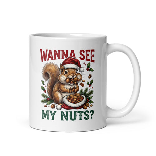 A white ceramic mug featuring a festive Christmas illustration of a squirrel wearing a Santa hat and eating nuts, with the text 'WANNA SEE MY NUTS?' in red and green lettering.